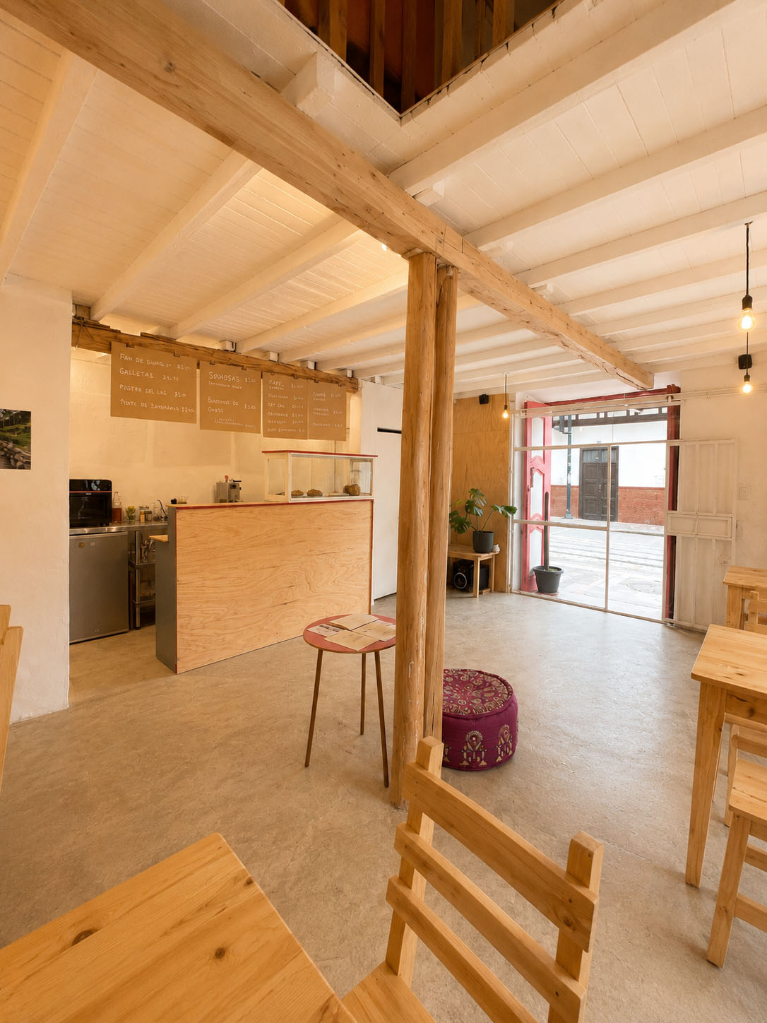 Café-Estudio — la esquina patrimonial con el rótulo de Paltaamanta, dos puertas rojas y el zócalo azul, frente a la línea del tranvía