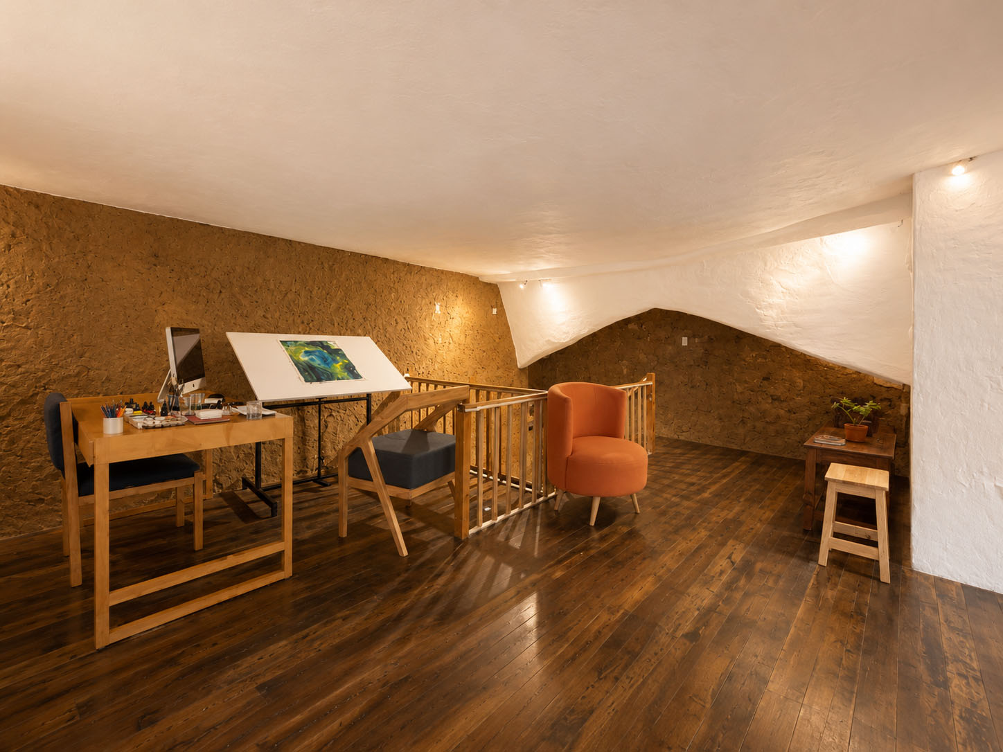 Café-Estudio — fachada de la casa patrimonial sobre la calle Estévez de Toral, con zócalo azul, puerta enmarcada en rosa rotulada «café-estudio» y un mural geométrico junto a la entrada