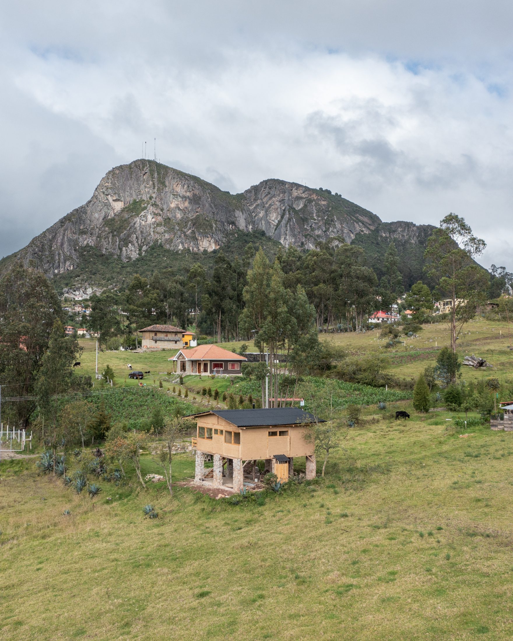 Casa Cojitambo — la casa pequeña en primer plano con el cerro Cojitambo al fondo, paredes de roca usadas como pared de escalada