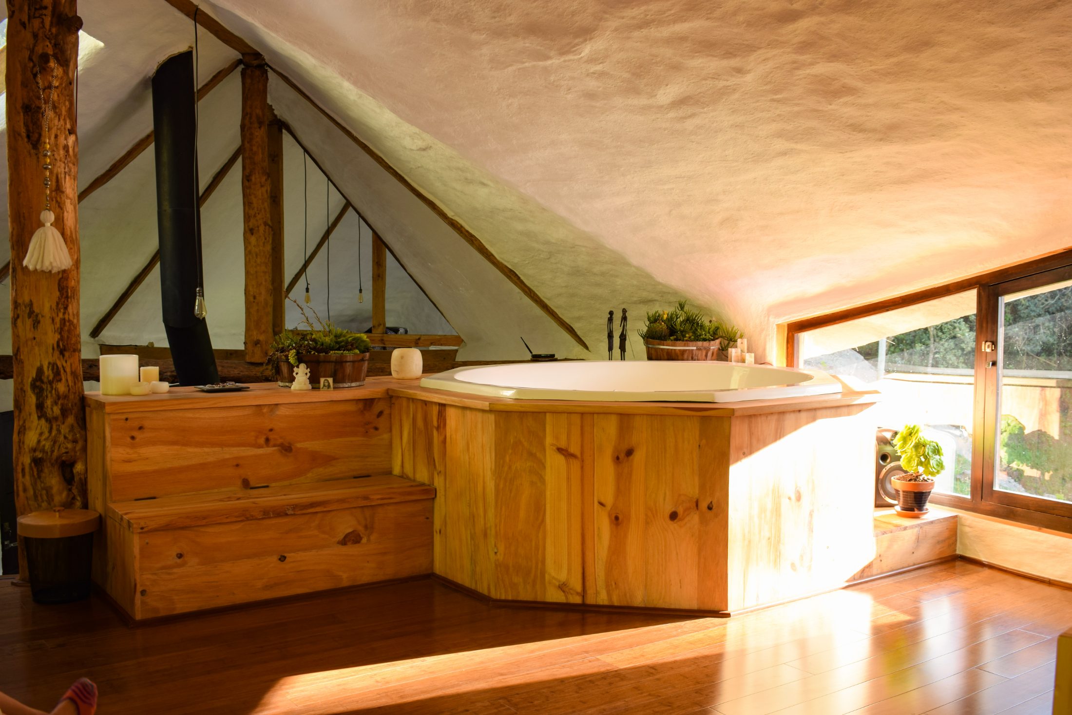 Casa Tarqui — bañera de madera bajo el alero, hora dorada