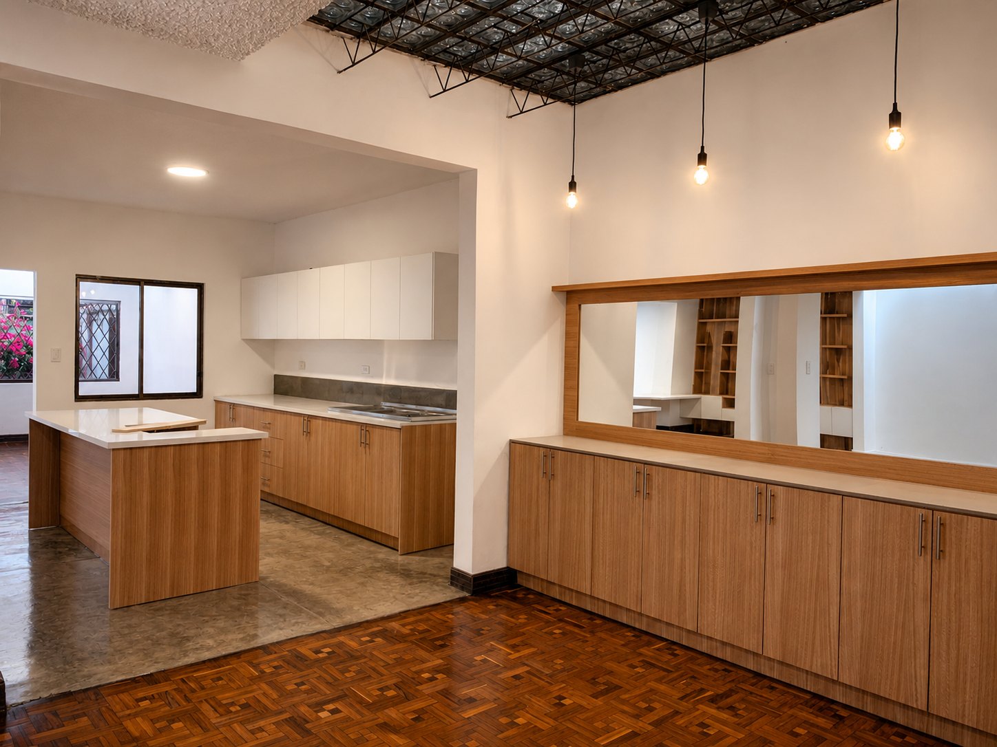 Departamento Vane y David — cocina con isla y mesones de cuarzo blanco, alacenas de roble y el tragaluz de botellas sobre cercha de hierro