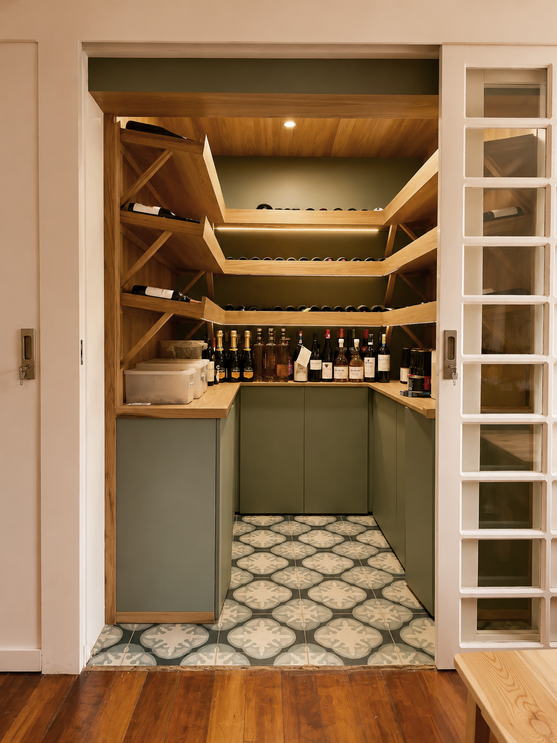 Dos Sucres — interior de la cava con repisas de madera en aspa, mobiliario verde y piso de baldosa hidráulica