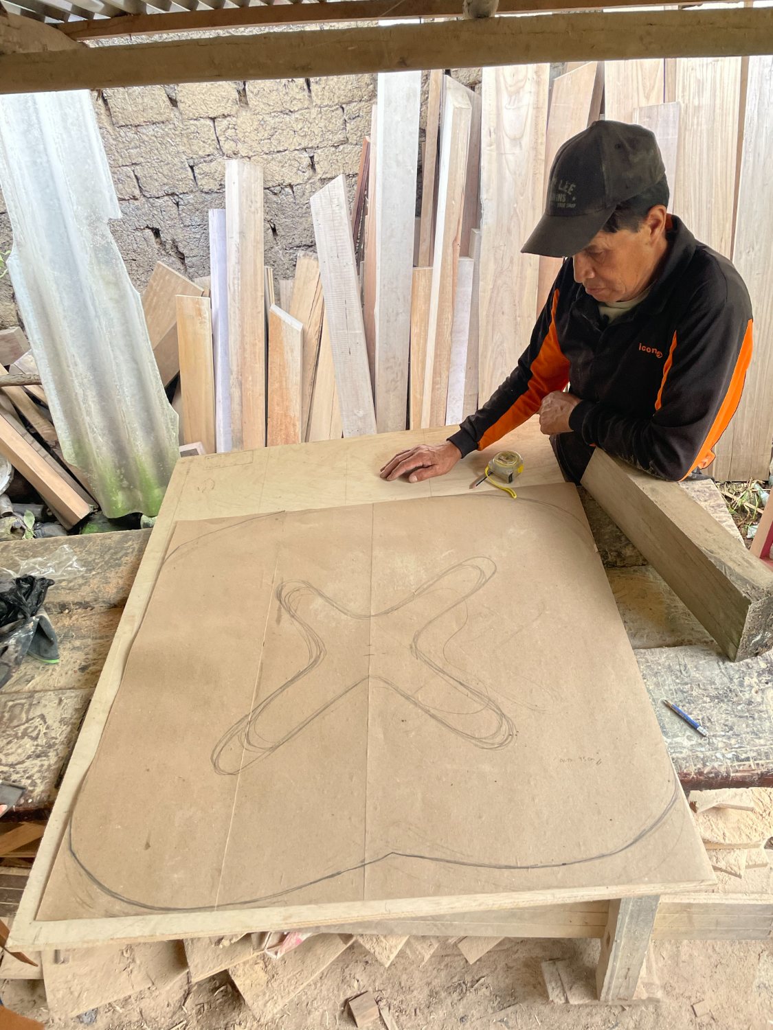 Trazo a mano de la base en cruz sobre un tablero en el taller
