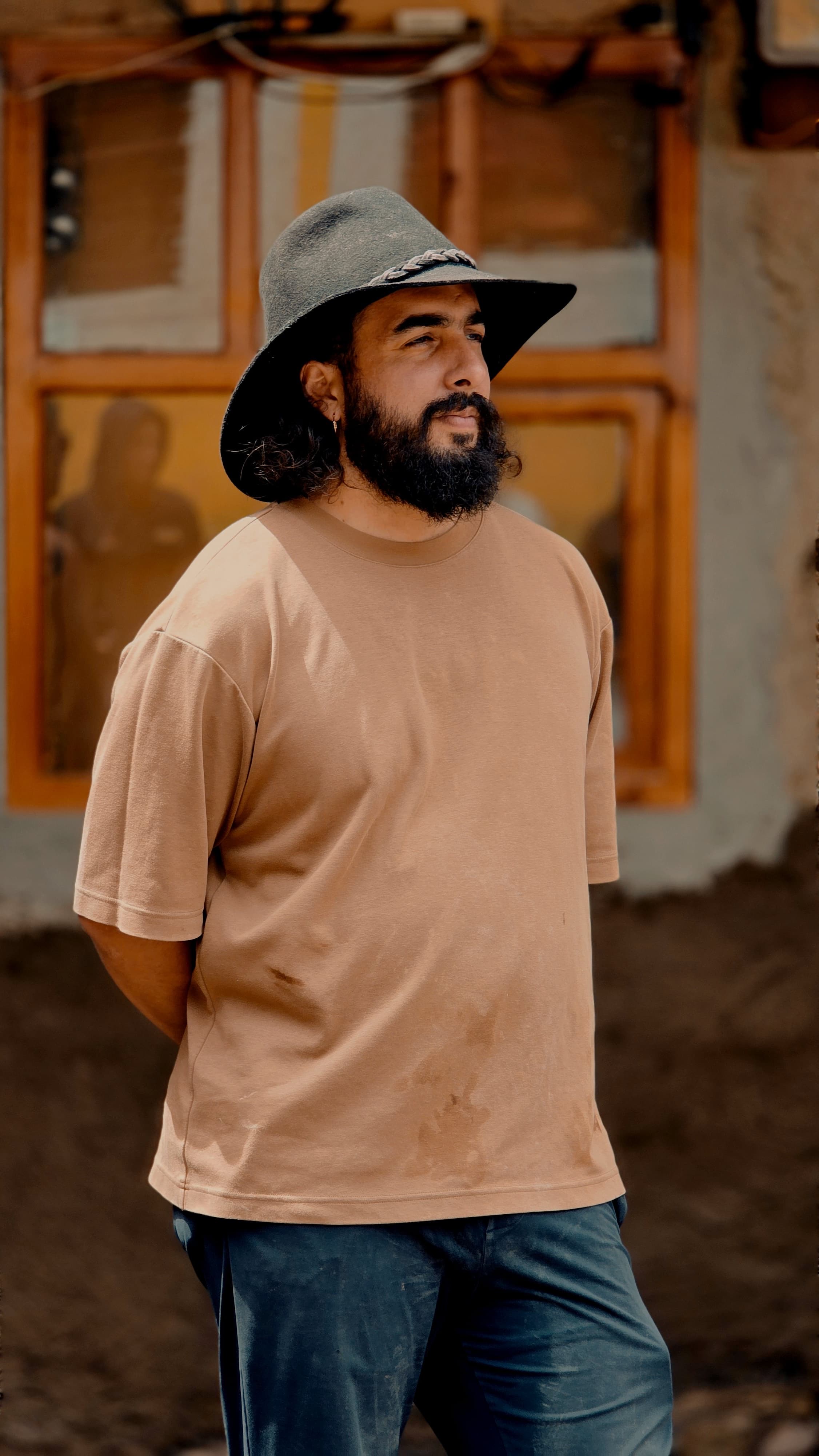 Pablo Andrés Cardoso, arquitecto a cargo del taller, con sombrero de fieltro frente a una ventana de madera